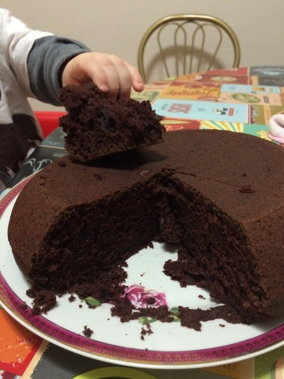 Ребёнок берёт кусок шоколадного пирога