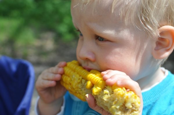 Ребёнок ест кукурузу