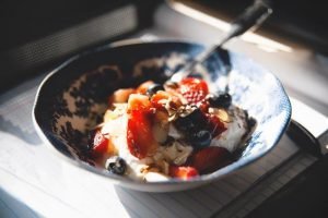 Йогурт с творогом и фруктами в тарелке