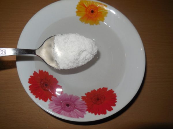 Соль в столовой ложке над тарелкой