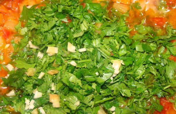 Зелень в кастрюле с овощной закуской
