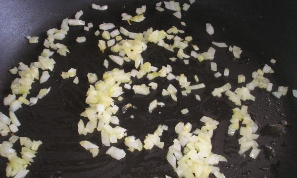 Мелко нарезанный репчатый лук в сковородке
