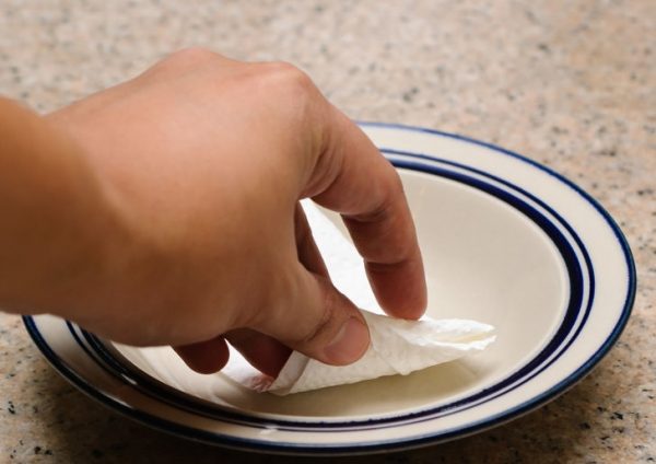 Смазывание тарелки маслом с помощью салфетки
