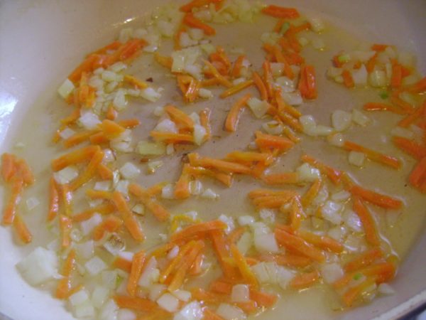 Лук и морковь в сковороде с маслом