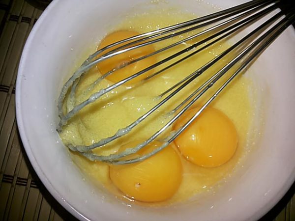 Яйца с сахарным песком в миске и железный венчик