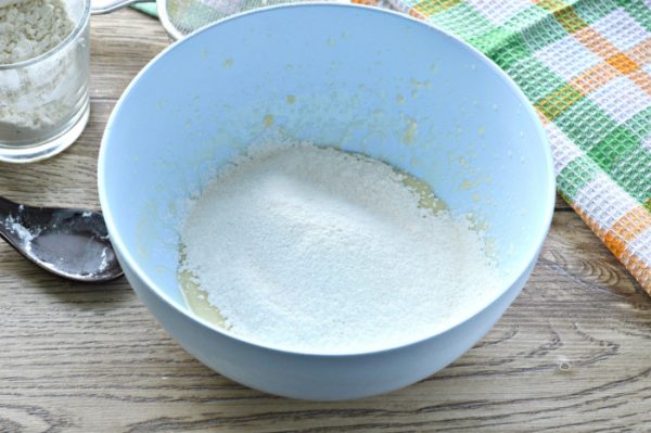 Просеянная пшеничная мука в миске со смесью ингредиентов для печенья на сковороде
