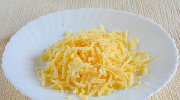 Тёртый твёрдый сыр в тарелке