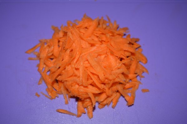 Тёртая морковь на разделочной доске