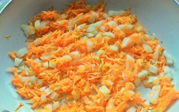 Тёртая морковь и рубленый репчатый лук в сковороде с антипригарным покрытием