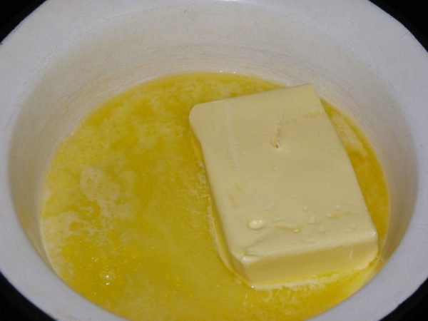 Растопленное сливочное масло в миске