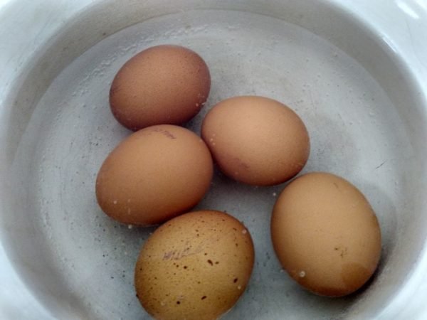 Куриные яйца в кастрюле с закипающей водой