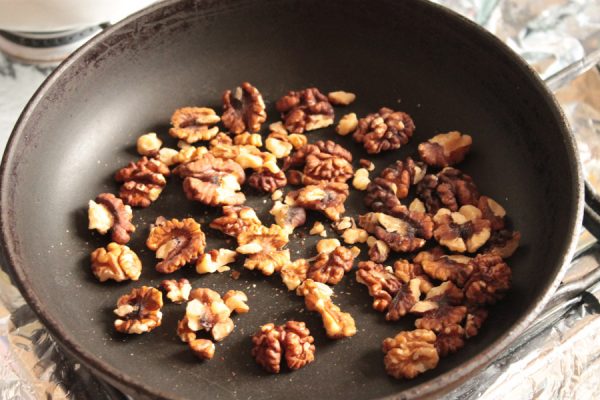 Ядра грецких орехов в большой сковороде без жира