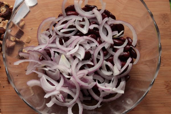 Консервированная красная фасоль и кольца синего лука в стеклянном салатнике