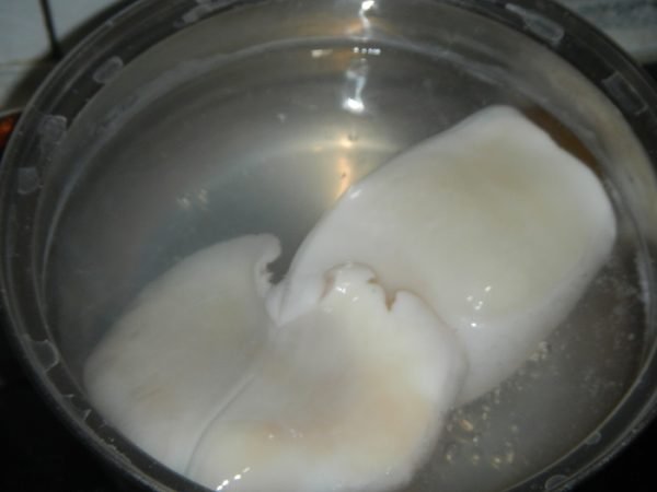 Тушка кальмара в кастрюле с водой