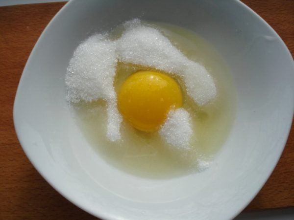 Сахарный песок и куриное яйцо в небольшой ёмкости
