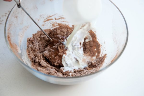 Шоколадное тесто и молоко в стеклянной миске