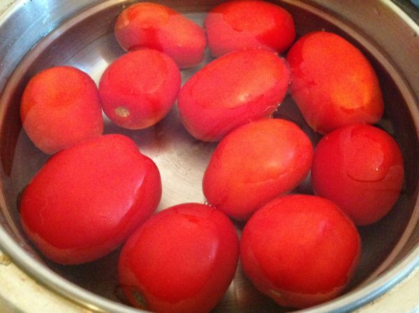 Свежие помидоры в большой кастрюле с водой