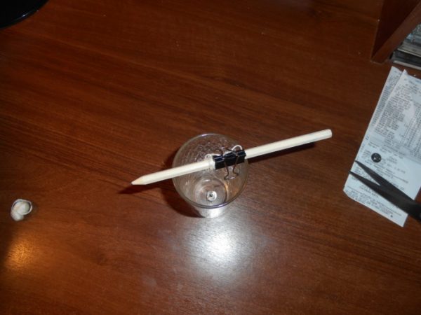 Фиксирование фитиля самодельной свечи карандашом и зажимом
