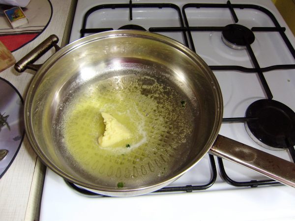 Растопленное масло на сковороде