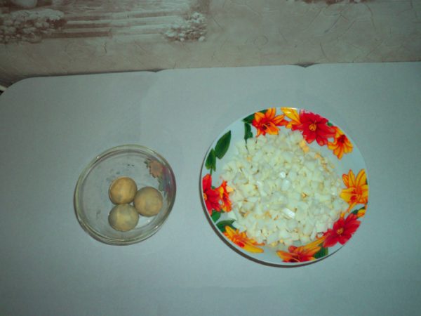 Варёные яичные желтки в стеклянной ёмкости и рубленые яйца в тарелке