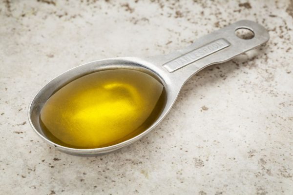 Растительное масло в мерной ложке
