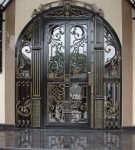 Стеклянная входная дверь в металлической решётке