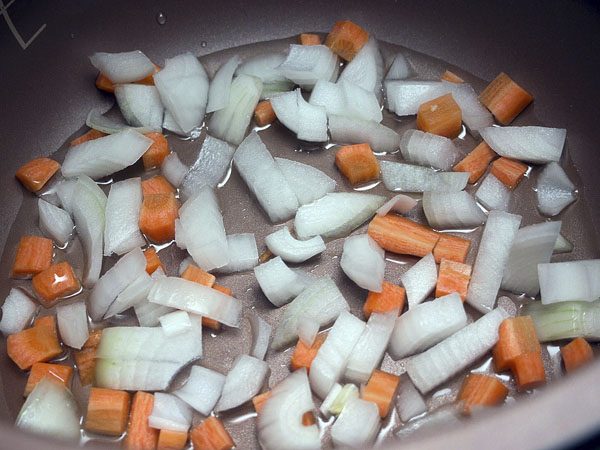 Кусочки моркови и репчатого лука в чаше мультиварки