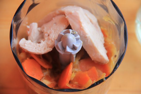 Кусочки отварной куриной грудки и тушёные овощи в чаше блендера