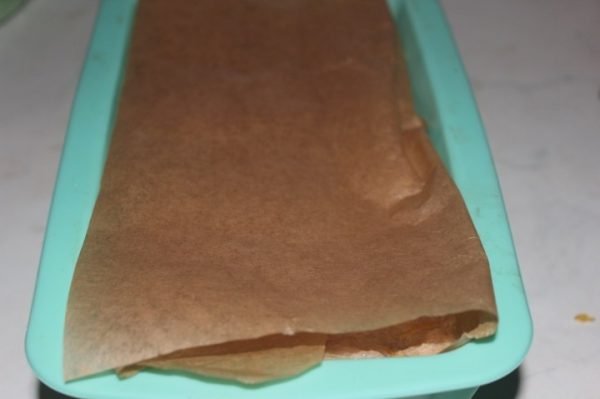Заготовка для паштета в голубой форме, прикрытая листом бумаги для запекания