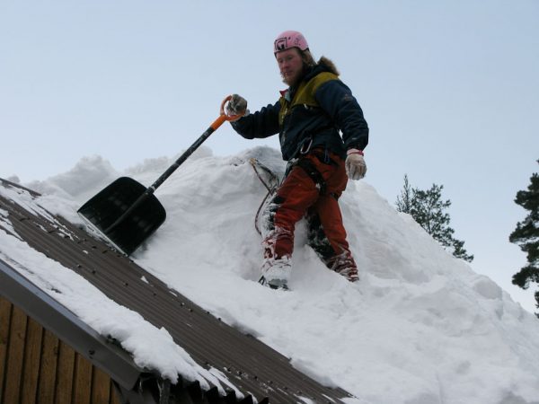 Удаление снега с крыши дома