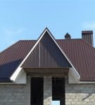 Сложная полувальмовая крыша из коричневого профнастила