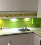 Зелёный фартук около рабочей зоны на кухне