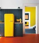 Жёлтый холодильник на тёмном фоне на кухне ретро