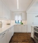 Белая кухня с ламинатом на полу