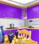 Фиолетовый гарнитур и белая стена на небольшой кухне