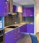 Фиолетовая мебель с белой столешницей на маленькой кухне