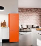 Холодильник оранжевого цвета на кухне в квартире-студии
