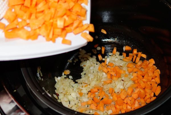 Морковь и лук выкладывают в мультиварку