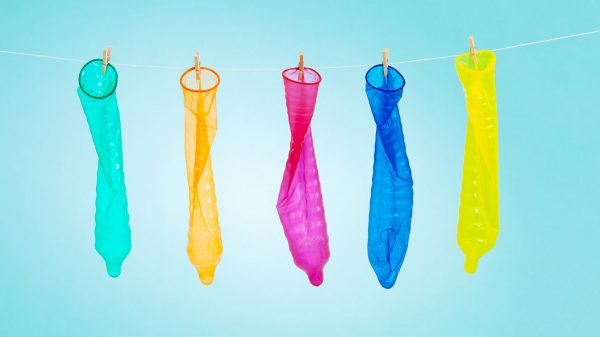 Разноцветные презервативы висят на верёвке