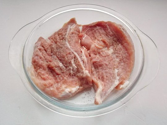 Кусочки свиной мякоти в стеклянной форме для выпекания