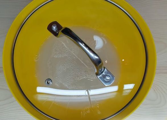 Опара для дрожжевого теста в жёлтой миске под стеклянной крышкой