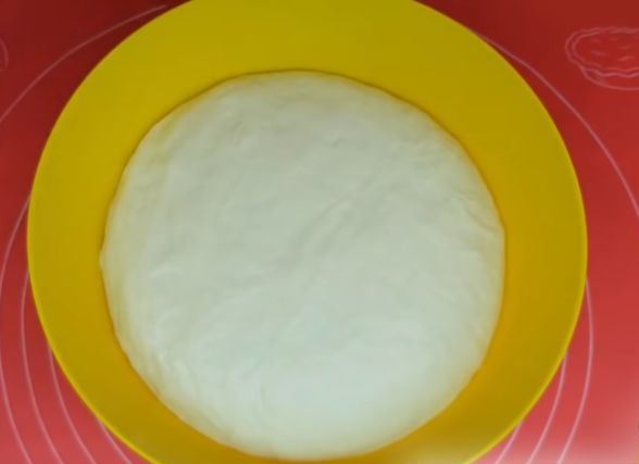 Дрожжевое тесто в большой жёлтой миске