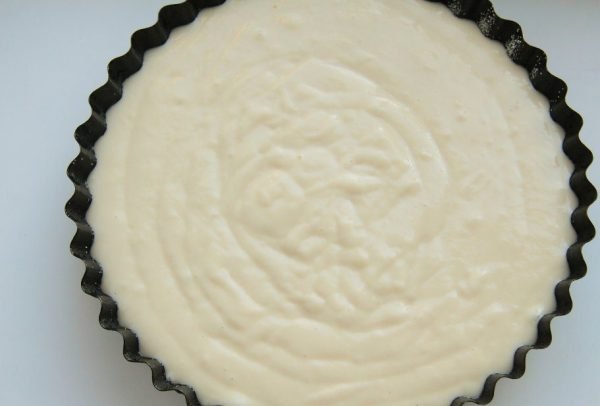 Жидкое тесто для пирога в круглой форме для выпекания с резными боковинами