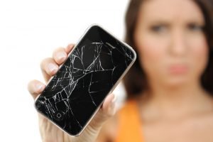 Разбитый телефон в руках девушки