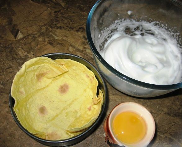 Лаваш в форме для запекания, миска со взбитыми белками и сырой яичный желток