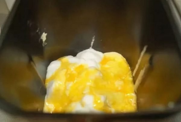 Взбитые белки и желтки с сахаром в чаше хлебопечки