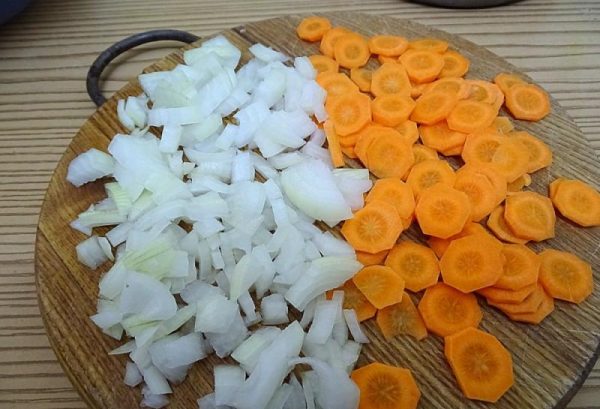 Нарезанные овощи для зажарки к гороховому супу на разделочной доске