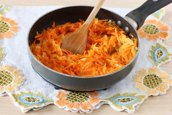 Зажарка из лука и моркови в сковороде на столе