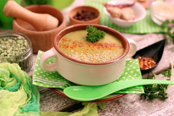 Гороховый суп-пюре с имбирем и шпинатом на сервированном столе