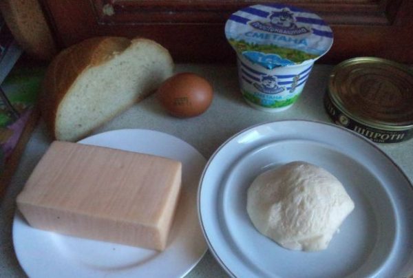 Продукты для приготовления горячих бутербродов со шпротами и сыром на столе